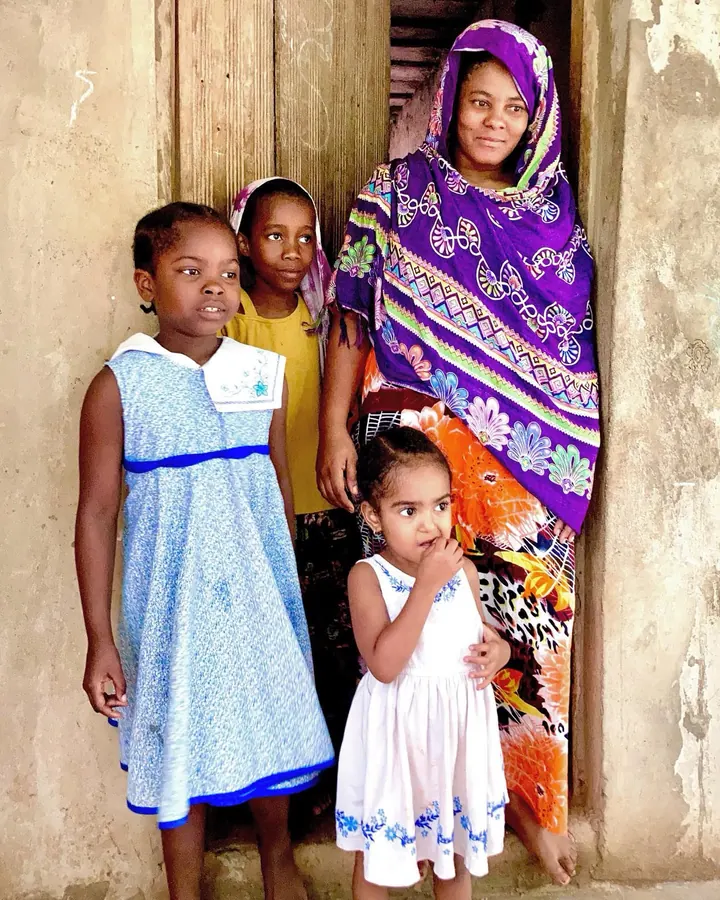 Une mère et ses trois enfants sur le seuil d’une maison à Zanzibar